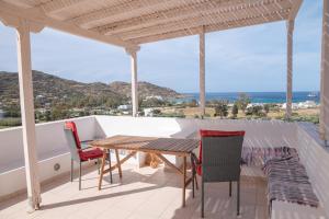 a table and chairs on a balcony with a view of the ocean at Mylopota Studio I in Mylopotas