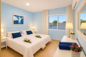 two beds in a room with two windows at GOLDEN BEACH MOGAN in Puerto de Mogán