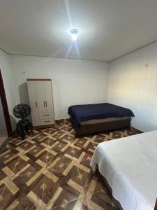 a bedroom with two beds and a ceiling fan at Kit net individual in Araguaína