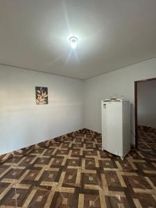 a white room with a refrigerator in the middle of it at Kit net individual in Araguaína