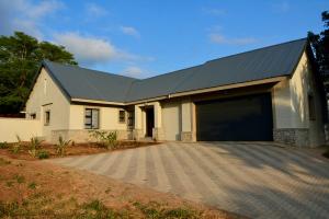 a large white house with a large garage at Solana Villa in Hazyview