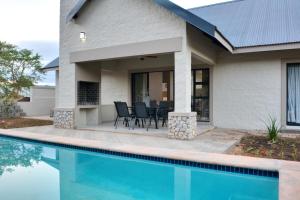 a house with a swimming pool next to a house at Solana Villa in Hazyview