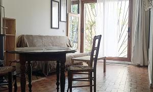 a room with a table and a chair and a window at Studio privé - maison de village in Valensole