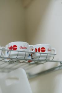 two coffee cups sitting on top of a wire rack at Aura Residence in San Biagio +5 photos