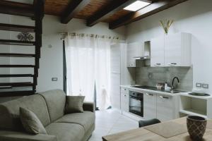 a living room with a couch and a kitchen at Aura Residence in San Biagio