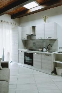 a kitchen with white cabinets and a sink at Aura Residence in San Biagio