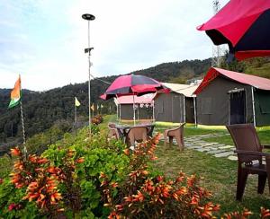 a group of tents with tables and umbrellas at Camping in Chail in Chail