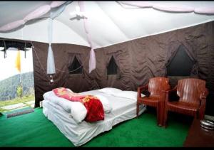 a bedroom with a tent with a bed and two chairs at Camping in Chail in Chail