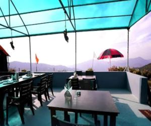 a restaurant with tables and chairs on a balcony at Camping in Chail in Chail