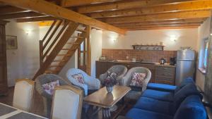 a living room with a blue couch and chairs at Domki Magda Rewal in Rewal