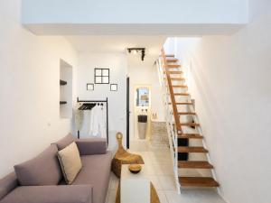 a living room with a couch and a staircase at SilVen Little Venice Stay, Mykonos Town in Mikonos +21 photos