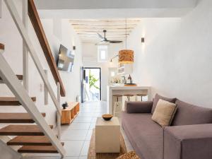 a living room with a purple couch and a staircase at SilVen Little Venice Stay, Mykonos Town in Mikonos