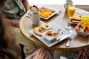 a woman sitting at a table with a plate of breakfast food at Hyatt Place Manati in Manati