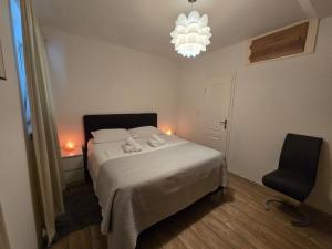 a bedroom with a bed and a chair and a chandelier at Braavos apartments Šibenik Deluxe near Marina in Šibenik +28 photos