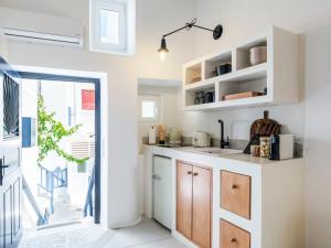 a kitchen with white cabinets and a window at SilVen Little Venice Stay, Mykonos Town in Mikonos