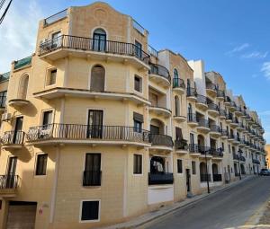 a building with balconies on the side of a street at Marsalforn Panorama Penthouse in Marsalforn