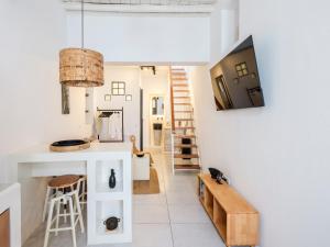 a kitchen and living room with white walls and a table at SilVen Little Venice Stay, Mykonos Town in Mikonos