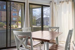 a wooden table and chairs in front of a window at 110 Pointes North Inn in Charlevoix