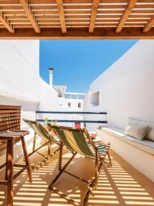 a room with a table and chairs on a balcony at SilVen Little Venice Stay, Mykonos Town in Mikonos