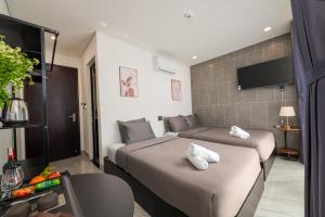 a hotel room with two beds and a tv at Kikihao Homestay Hội An Near Tra Que Village in Hoi An
