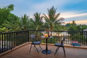 a patio with a table and chairs on a balcony at Kikihao Homestay Hội An Near Tra Que Village in Hoi An