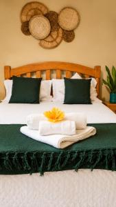 a bed with two towels and a flower on it at Casa das Flores in Prado