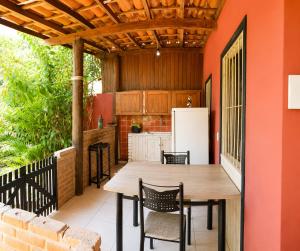 an outdoor kitchen with a wooden table and chairs at Casa das Flores in Prado