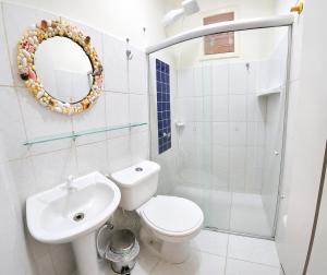 a bathroom with a toilet and a sink and a mirror at Casa das Flores in Prado