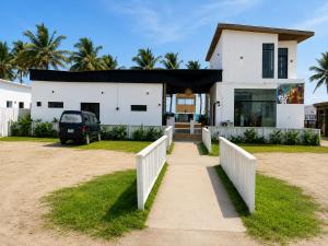 a house on the beach with a white fence at Ileero Homes The Beachfront in Lekki