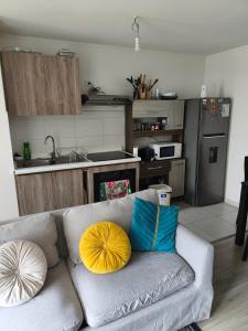 a living room with a couch with two yellow and blue pillows at Departamento Temuco in Temuco