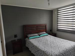 a bedroom with a bed with two pillows on it at Departamento Temuco in Temuco