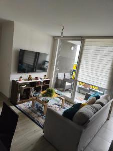 a living room with a couch and a tv at Departamento Temuco in Temuco