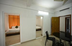 a room with a bedroom with a bed and a table at Norwegian Guest House in Anachal