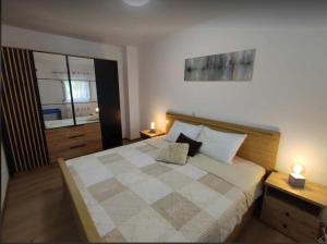 a bedroom with a large bed with two lamps at Apartmani Matan Vir in Vir