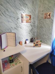 a white desk with a table and books on it at Studio Denisa in Călan