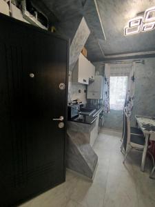 a small kitchen with a black door and a table at Studio Denisa in Călan +6 photos