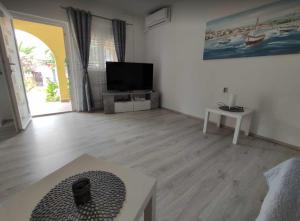 a living room with a flat screen tv and a table at Apartmani Matan Vir in Vir