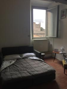 a bedroom with a bed and a large window at Loft with a ducal view in Urbino