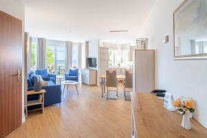 a living room with a blue couch and a kitchen at SEETELHOTEL Ostseeresidenz Ahlbeck in Ahlbeck