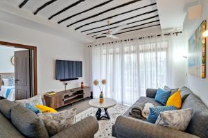 a living room with two couches and a tv at Binti House- Sultan Palace in Mombasa