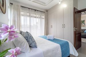 a bedroom with a white bed with purple flowers on it at Binti House- Sultan Palace in Mombasa +9 photos