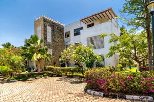 a building with a courtyard with flowers and trees at Binti House- Sultan Palace in Mombasa