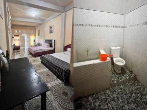 a bathroom with a bed and a sink in a room at FURQAN GUEST HOUSE Family in Iboih
