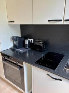 a kitchen with a black counter top with a coffee maker at Boutique Apartment mit Balkon, Küche, Zentral, HDZ, BALI THERME, GOP in Bad Oeynhausen +3 photos