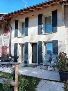 a building with two lawn chairs in front of it at BROCHETA GUEST HOUSE in Belluno