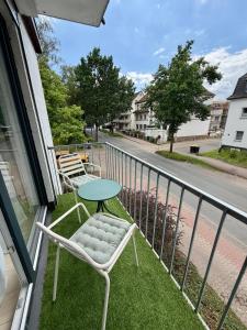 a balcony with two chairs and a table and a street at Boutique Apartment mit Balkon, Küche, Zentral, HDZ, BALI THERME, GOP in Bad Oeynhausen
