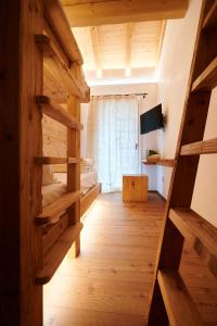 a room with wooden floors and a bed and a window at BROCHETA GUEST HOUSE in Belluno