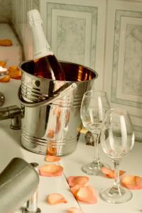 a bottle of wine in a bucket next to two wine glasses at HOTEL MADURAI in Ambato