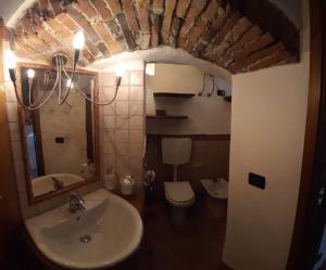 a bathroom with a sink and a toilet and a mirror at Il Nido di Ory in Clusane sul Lago