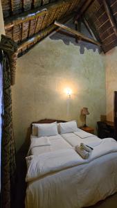 a bedroom with a large bed with white sheets at Afrika Lodge in Kempton Park +41 photos